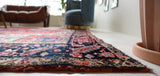 Antique Persian area rug in a living room setting, pile rug, vintage rug, portland, rug shop, bright colors, wild shaman, soft rug, bold color, Portland, Oregon, rug store, rug shop, local shop, antique rug, Persian rug, handmade rug, wool rug, distressed rug