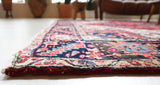 Antique Persian area rug in a living room setting, pile rug, vintage rug, portland, rug shop, bright colors, wild shaman, soft rug, bold color, Portland, Oregon, rug store, rug shop, local shop, antique rug, Persian rug, handmade rug, wool rug, distressed rug