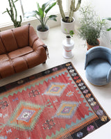 Vintage kilim rug in living room setting, old rug, antique rug, pastel colors, faded colors, Turkish rug, vintage rug, soft rug, Portland, Oregon, rug store, rug shop, local shop, earthy tones, earthy colors, warm colors
