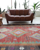 Vintage kilim rug in living room setting, old rug, antique rug, pastel colors, faded colors, Turkish rug, vintage rug, soft rug, Portland, Oregon, rug store, rug shop, local shop, earthy tones, earthy colors, warm colors