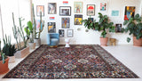 Antique Persian area rug in a living room setting, pile rug, vintage rug, portland, rug shop, bright colors, wild shaman, soft rug, bold color, Portland, Oregon, rug store, rug shop, local shop, antique rug, Persian rug, handmade rug, wool rug, distressed rug