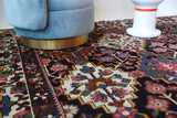 Antique Persian area rug in a living room setting, pile rug, vintage rug, portland, rug shop, bright colors, wild shaman, soft rug, bold color, Portland, Oregon, rug store, rug shop, local shop, antique rug, Persian rug, handmade rug, wool rug, distressed rug