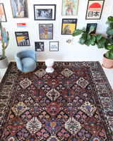 Antique Persian area rug in a living room setting, pile rug, vintage rug, portland, rug shop, bright colors, wild shaman, soft rug, bold color, Portland, Oregon, rug store, rug shop, local shop, antique rug, Persian rug, handmade rug, wool rug, distressed rug