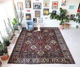Antique Persian area rug in a living room setting, pile rug, vintage rug, portland, rug shop, bright colors, wild shaman, soft rug, bold color, Portland, Oregon, rug store, rug shop, local shop, antique rug, Persian rug, handmade rug, wool rug, distressed rug