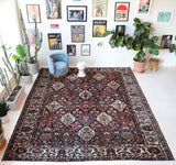 Antique Persian area rug in a living room setting, pile rug, vintage rug, portland, rug shop, bright colors, wild shaman, soft rug, bold color, Portland, Oregon, rug store, rug shop, local shop, antique rug, Persian rug, handmade rug, wool rug, distressed rug