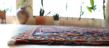 Antique Persian area rug in a living room setting, pile rug, vintage rug, portland, rug shop, bright colors, wild shaman, soft rug, bold color, Portland, Oregon, rug store, rug shop, local shop, antique rug, Persian rug, handmade rug, wool rug
