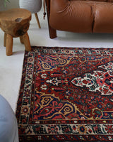 Antique Persian area rug in a living room setting, pile rug, vintage rug, portland, rug shop, bright colors, wild shaman, soft rug, bold color, Portland, Oregon, rug store, rug shop, local shop, antique rug, Persian rug, handmade rug, wool rug, distressed rug