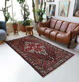 Antique Persian area rug in a living room setting, pile rug, vintage rug, portland, rug shop, bright colors, wild shaman, soft rug, bold color, Portland, Oregon, rug store, rug shop, local shop, antique rug, Persian rug, handmade rug, wool rug, distressed rug