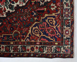 Antique Persian area rug in a living room setting, pile rug, vintage rug, portland, rug shop, bright colors, wild shaman, soft rug, bold color, Portland, Oregon, rug store, rug shop, local shop, antique rug, Persian rug, handmade rug, wool rug, distressed rug