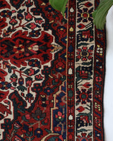 Antique Persian area rug in a living room setting, pile rug, vintage rug, portland, rug shop, bright colors, wild shaman, soft rug, bold color, Portland, Oregon, rug store, rug shop, local shop, antique rug, Persian rug, handmade rug, wool rug, distressed rug