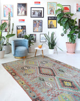 Vintage kilim rug in living room setting, old rug, antique rug, pastel colors, faded colors, Turkish rug, vintage rug, soft rug, Portland, Oregon, rug store, rug shop, local shop, earthy tones, earthy colors, warm colors