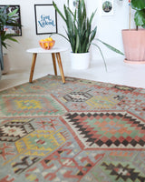 Vintage kilim rug in living room setting, old rug, antique rug, pastel colors, faded colors, Turkish rug, vintage rug, soft rug, Portland, Oregon, rug store, rug shop, local shop, earthy tones, earthy colors, warm colors
