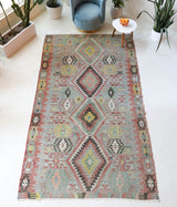 Vintage kilim rug in living room setting, old rug, antique rug, pastel colors, faded colors, Turkish rug, vintage rug, soft rug, Portland, Oregon, rug store, rug shop, local shop, earthy tones, earthy colors, warm colors