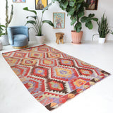 Vintage kilim rug in room decor setting, old rug, antique rug, pastel colors, faded colors, Turkish rug, vintage rug, soft rug, Portland, Oregon, rug store, rug shop, local shop, antique kilim rug, bold colors, bright colors, faded colors