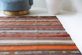 Vintage kilim rug in living room setting, old rug, antique rug, pastel colors, faded colors, Turkish rug, vintage rug, soft rug, Portland, Oregon, rug store, rug shop, local shop, earthy tones, earthy colors, warm colors
