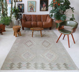 Vintage kilim rug in living room setting, old rug, antique rug, pastel colors, faded colors, Turkish rug, vintage rug, soft rug, Portland, Oregon, rug store, rug shop, local shop, earthy tones, earthy colors, warm colors