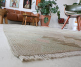 Vintage kilim rug in living room setting, old rug, antique rug, pastel colors, faded colors, Turkish rug, vintage rug, soft rug, Portland, Oregon, rug store, rug shop, local shop, earthy tones, earthy colors, warm colors