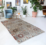 Vintage kilim rug in living room setting, old rug, antique rug, pastel colors, faded colors, Turkish rug, vintage rug, soft rug, Portland, Oregon, rug store, rug shop, local shop, earthy tones, earthy colors, warm colors