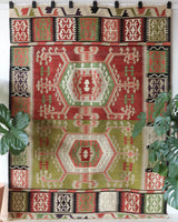 Vintage kilim rug in living room setting, old rug, antique rug, pastel colors, faded colors, Turkish rug, vintage rug, soft rug, Portland, Oregon, rug store, rug shop, local shop, earthy tones, earthy colors, warm colors