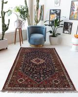 Antique Persian  rug in a living room setting, pile rug, vintage rug, portland, rug shop, bright colors, wild shaman, soft rug, bold color, Portland, Oregon, rug store, rug shop, local shop, antique rug, Persian rug, handmade rug, wool rug, distressed rug