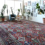 Antique Persian area rug in a living room setting, pile rug, vintage rug, portland, rug shop, bright colors, wild shaman, soft rug, bold color, Portland, Oregon, rug store, rug shop, local shop, antique rug, Persian rug, handmade rug, wool rug, distressed rug