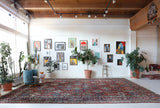 Antique Persian area rug in a living room setting, pile rug, vintage rug, portland, rug shop, bright colors, wild shaman, soft rug, bold color, Portland, Oregon, rug store, rug shop, local shop, antique rug, Persian rug, handmade rug, wool rug, distressed rug