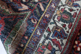 Antique Persian area rug in a living room setting, pile rug, vintage rug, portland, rug shop, bright colors, wild shaman, soft rug, bold color, Portland, Oregon, rug store, rug shop, local shop, antique rug, Persian rug, handmade rug, wool rug, distressed rug