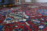 Antique Persian area rug in a living room setting, pile rug, vintage rug, portland, rug shop, bright colors, wild shaman, soft rug, bold color, Portland, Oregon, rug store, rug shop, local shop, antique rug, Persian rug, handmade rug, wool rug, distressed rug