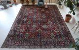 Antique Persian area rug in a living room setting, pile rug, vintage rug, portland, rug shop, bright colors, wild shaman, soft rug, bold color, Portland, Oregon, rug store, rug shop, local shop, antique rug, Persian rug, handmade rug, wool rug, distressed rug
