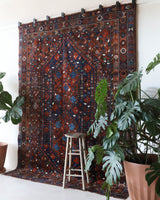 Antique Persian area rug in a living room setting, pile rug, vintage rug, portland, rug shop, bright colors, wild shaman, soft rug, bold color, Portland, Oregon, rug store, rug shop, local shop, antique rug, Persian rug, handmade rug, wool rug, distressed rug