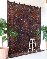 Antique Persian area rug in a living room setting, pile rug, vintage rug, portland, rug shop, bright colors, wild shaman, soft rug, bold color, Portland, Oregon, rug store, rug shop, local shop, antique rug, Persian rug, handmade rug, wool rug, distressed rug