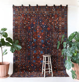 Antique Persian area rug in a living room setting, pile rug, vintage rug, portland, rug shop, bright colors, wild shaman, soft rug, bold color, Portland, Oregon, rug store, rug shop, local shop, antique rug, Persian rug, handmade rug, wool rug, distressed rug