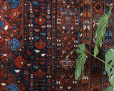 Antique Persian area rug in a living room setting, pile rug, vintage rug, portland, rug shop, bright colors, wild shaman, soft rug, bold color, Portland, Oregon, rug store, rug shop, local shop, antique rug, Persian rug, handmade rug, wool rug, distressed rug
