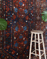 Antique Persian area rug in a living room setting, pile rug, vintage rug, portland, rug shop, bright colors, wild shaman, soft rug, bold color, Portland, Oregon, rug store, rug shop, local shop, antique rug, Persian rug, handmade rug, wool rug, distressed rug