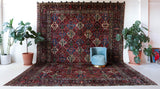 Antique Persian area rug in a living room setting, pile rug, vintage rug, portland, rug shop, bright colors, wild shaman, soft rug, bold color, Portland, Oregon, rug store, rug shop, local shop, antique rug, Persian rug, handmade rug, wool rug, distressed rug