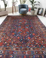 Antique Persian area rug in a living room setting, pile rug, vintage rug, portland, rug shop, bright colors, wild shaman, soft rug, bold color, Portland, Oregon, rug store, rug shop, local shop, antique rug, Persian rug, handmade rug, wool rug, distressed rug
