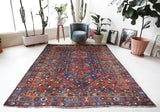 Antique Persian area rug in a living room setting, pile rug, vintage rug, portland, rug shop, bright colors, wild shaman, soft rug, bold color, Portland, Oregon, rug store, rug shop, local shop, antique rug, Persian rug, handmade rug, wool rug, distressed rug