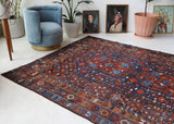 Antique Persian area rug in a living room setting, pile rug, vintage rug, portland, rug shop, bright colors, wild shaman, soft rug, bold color, Portland, Oregon, rug store, rug shop, local shop, antique rug, Persian rug, handmade rug, wool rug, distressed rug