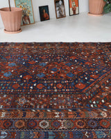 Antique Persian area rug in a living room setting, pile rug, vintage rug, portland, rug shop, bright colors, wild shaman, soft rug, bold color, Portland, Oregon, rug store, rug shop, local shop, antique rug, Persian rug, handmade rug, wool rug, distressed rug