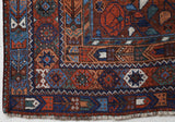 Antique Persian area rug in a living room setting, pile rug, vintage rug, portland, rug shop, bright colors, wild shaman, soft rug, bold color, Portland, Oregon, rug store, rug shop, local shop, antique rug, Persian rug, handmade rug, wool rug, distressed rug