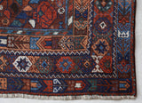 Antique Persian area rug in a living room setting, pile rug, vintage rug, portland, rug shop, bright colors, wild shaman, soft rug, bold color, Portland, Oregon, rug store, rug shop, local shop, antique rug, Persian rug, handmade rug, wool rug, distressed rug