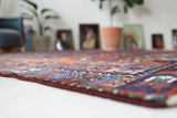 Antique Persian area rug in a living room setting, pile rug, vintage rug, portland, rug shop, bright colors, wild shaman, soft rug, bold color, Portland, Oregon, rug store, rug shop, local shop, antique rug, Persian rug, handmade rug, wool rug, distressed rug