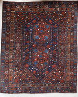 Antique Persian area rug in a living room setting, pile rug, vintage rug, portland, rug shop, bright colors, wild shaman, soft rug, bold color, Portland, Oregon, rug store, rug shop, local shop, antique rug, Persian rug, handmade rug, wool rug, distressed rug