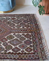 Vintage kilim rug in living room setting, old rug, antique rug, pastel colors, faded colors, Turkish rug, vintage rug, soft rug, Portland, Oregon, rug store, rug shop, local shop, earthy tones, earthy colors, warm colors