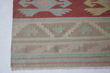 Vintage kilim rug in living room setting, old rug, antique rug, pastel colors, faded colors, Turkish rug, vintage rug, soft rug, Portland, Oregon, rug store, rug shop, local shop, earthy tones, earthy colors, warm colors, flat weave