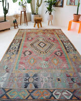 Vintage kilim rug in living room setting, old rug, antique rug, pastel colors, faded colors, Turkish rug, vintage rug, soft rug, Portland, Oregon, rug store, rug shop, local shop, earthy tones, earthy colors, warm colors