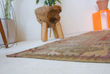 Vintage kilim rug in living room setting, old rug, antique rug, pastel colors, faded colors, Turkish rug, vintage rug, soft rug, Portland, Oregon, rug store, rug shop, local shop, earthy tones, earthy colors, warm colors