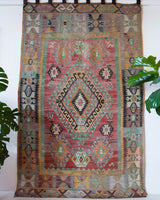 Vintage kilim rug in living room setting, old rug, antique rug, pastel colors, faded colors, Turkish rug, vintage rug, soft rug, Portland, Oregon, rug store, rug shop, local shop, earthy tones, earthy colors, warm colors