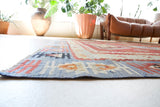 Vintage kilim rug in room decor setting, old rug, antique rug, pastel colors, faded colors, Turkish rug, vintage rug, soft rug, Portland, Oregon, rug store, rug shop, local shop, bold colors, bright colors, faded colors