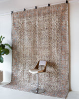 Area rug in a living room setting, pile rug, Turkish rug, old rug, antique rug, pastel colors, faded colors, Turkish rug, vintage rug, soft rug, Portland, Oregon, rug store, rug shop, local shop, distressed rug, worn out rug